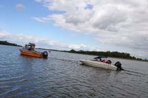 policyjna łódź ciągnie uszkodzoną motorówkę