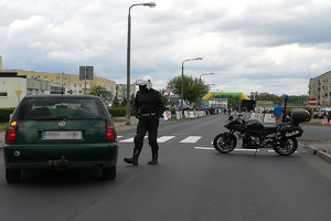 policjant na motocyklu informuje kierowcę jak jechać ze względu na zmianę organizacji ruchu