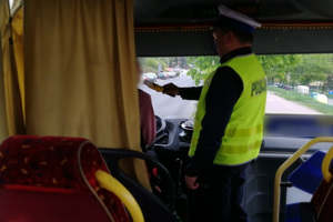 Policjant kontroluje trzeźwość kierowcy autokaru.