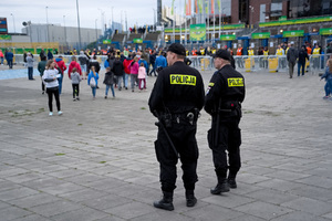 Dwaj policjanci stoją i obserwują teren przed stadionem