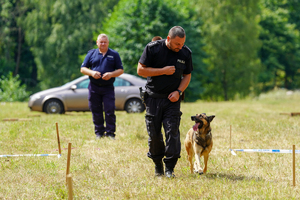 pies policyjny idzie obok policjanta