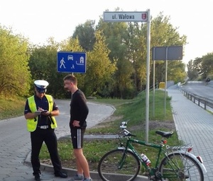 Policjant kontroluje rowerzystę