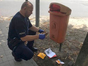 Policjant zabezpiecza wyrzucone puste koperty