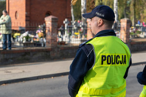 policjant obserwuje teren cmentarza