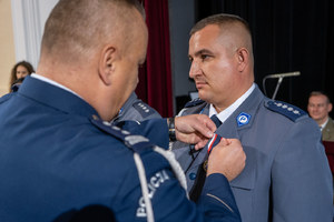Komendant Wojewódzki przypina policjantowi odznakę