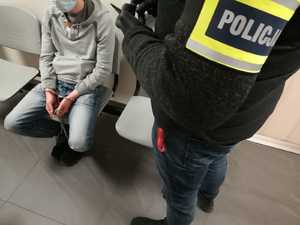 policjant stoi nad zatrzymanym mężczyzną