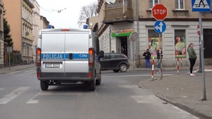 Radiowóz policji jadący ulicą, który nadaje informacje o ograniczeniach związanych z koronawirusem