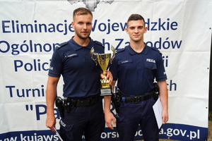dwaj policjanci, którzy zajęli pierwsze miejsce pozują z pucharem do zdjęcia