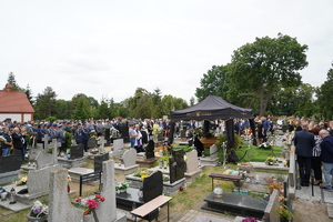 Uczestnicy pogrzebu na terenie cmentarza.