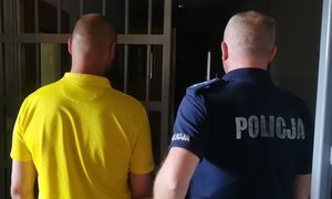 Policjant stoi obok zatrzymanego mężczyzny