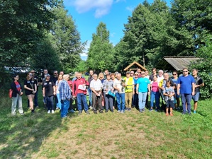 Zdjęcie grupowe uczestników rajdu na tle lasu. plik jpg
