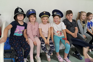 Dzieci w czapkach policyjnych z różnych krajów. plik jpg.