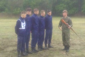 żołnierz tłumaczy uczniom klasy policyjnej zasady strzelania z karabinka