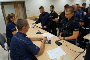 odprawiający do służby policjanci podpisują udającym się na służbę funkcjonariuszom notatniki