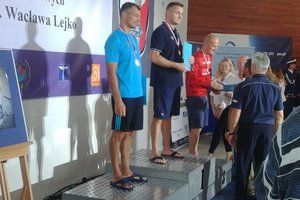 uczestnicy pływania stoją na podium i odbierają medale
