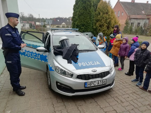 policjant prezentuje dzieciom radiowóz i sprzęt policyjny