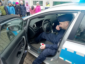 policjant prezentuje dzieciom radiowóz i sprzęt policyjny