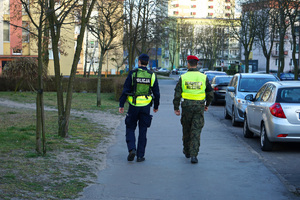policjant z żandarmem idą chodnikiem i patrolują ulice