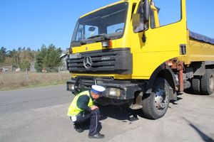 policjant ruchu drogowego kontroluje pojazd