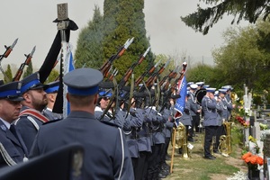 policjanci kompanii honorowej oddają salwę na cmentarzu