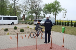 uczestnik pod czujnym okiem policjanta pokonuje kolejną przeszkodę