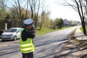 policjant mierzy prędkość nadjeżdżających pojazdów