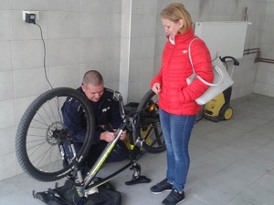 Policjant znakuje rower, obok którego stoi właścicielka.