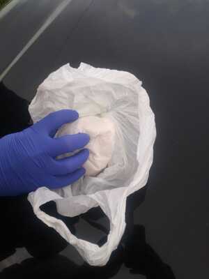 policjant trzyma paczkę z anfetaminą