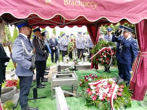 uczestnicy pogrzebu oddają hołd zmarłemu