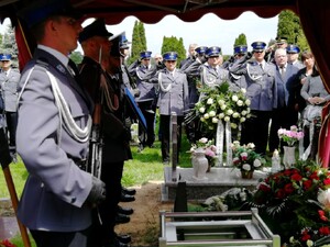 uczestnicy pogrzebu oddają hołd zmarłemu
