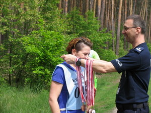 Zastępca Naczelnika Kadr i Szkolenia KWP w Bydgoszczy zakłada pamiątkowy medal kolejnej uczestniczce.