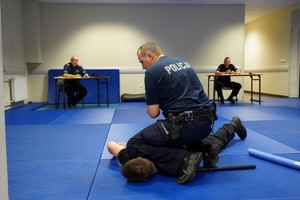 Policjant stosuje chwyt obezwładniający na pozorancie