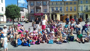 Dzieciaki siedzące na rynku i czekające na pokazy