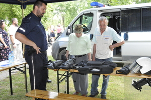 Policjant rozmawia z mieszkańcami uczestniczącymi w pikniku