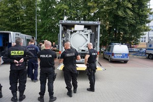 Policjanci oglądają specjalistyczny samochód do przewozu ładunków wybuchowych