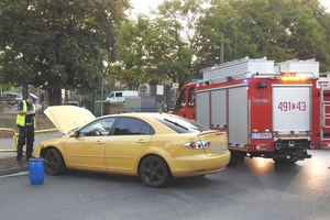 Policjant &quot;drogówki&quot; robi oględziny miejsca kolizji.