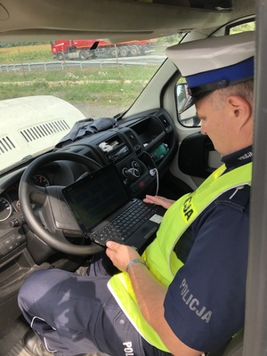 Policjant odczytuje wyniki badania spalin na komputerze