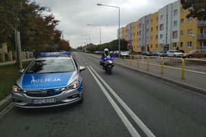 Radiowóz i policjant na motorze jadą na zabezpieczenie biegu