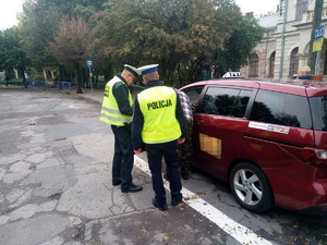 Policjant i funkcjonariusz ITD kontrolują taksówkarza