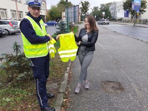 Policjant eksponuje kamizelkę odblaskową