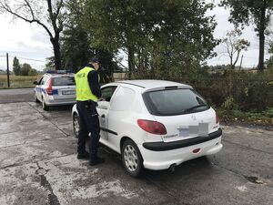 Policjant z "drogówki" kontroluje kierowcę peugeota