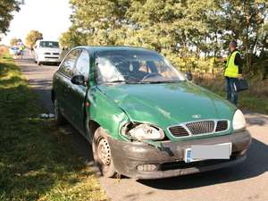 Rozbite daewoo, a obok policjanci prowadzą oględziny