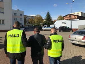 Policjanci prowadzą zatrzymanego