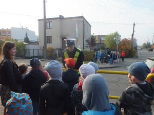 Policjant rozmawia z dziećmi przy przejściu dla pieszych