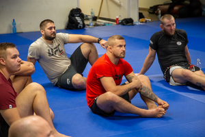 Uczestnicy szkolenia siedzą na matach