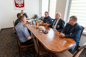 zaproszeni goście siedzą przy stole razem z komendantem