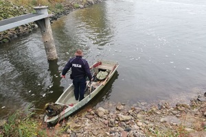 Policjant na przycumowanej łodzi kłusownika