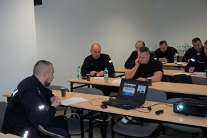 policjant przemawia do innych policjantów