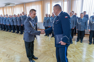 Komendant wręcza nagrodę policjantowi