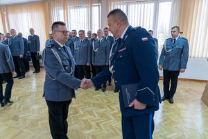 Komendant wręcza nagrodę policjantowi